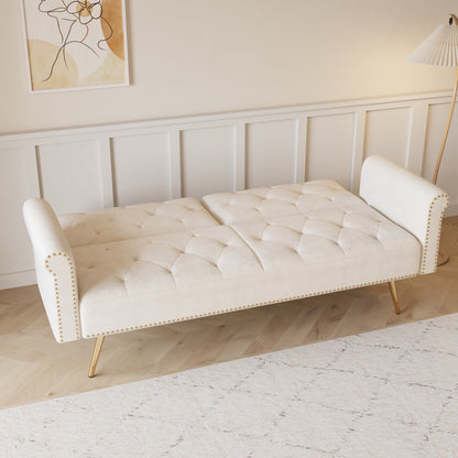 A 69.7-inch-long sofa bed covered in beige velvet fabric, featuring nail head trim and accompanied by a matching throw pillow